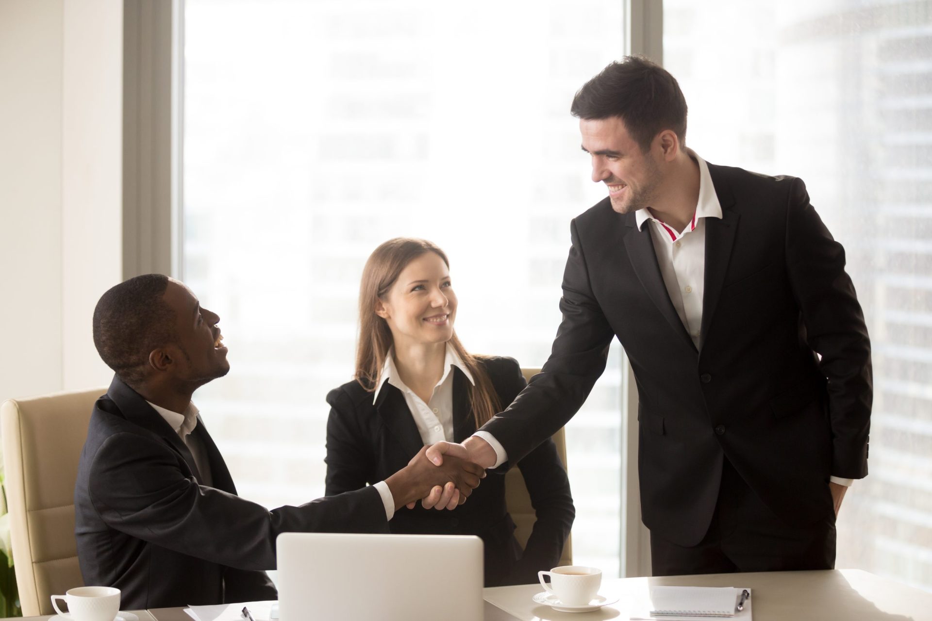afro-american-caucasian-cheerful-businessmen-handshaking-scaled.jpg