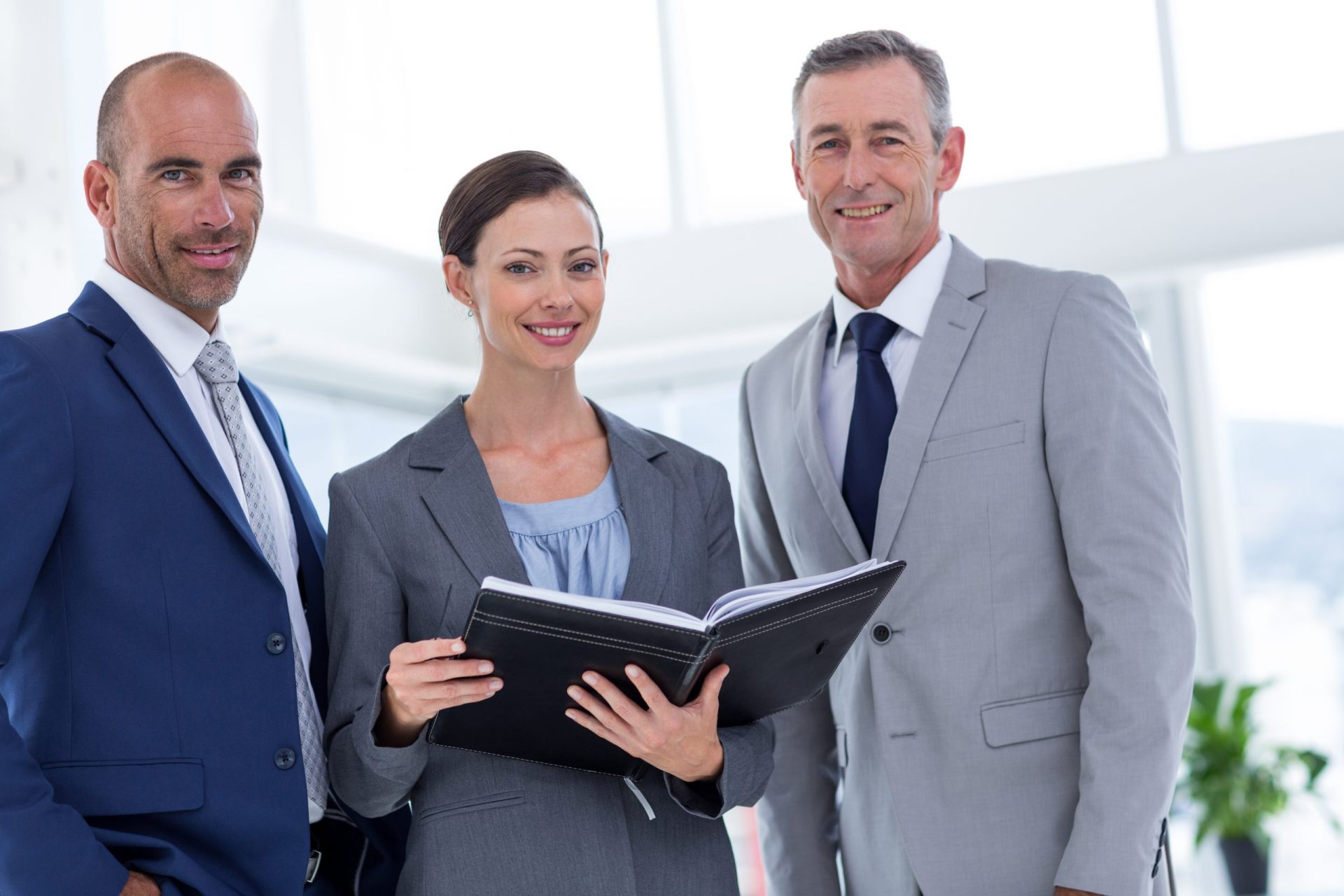businesswoman-showing-her-notes-her-colleagues-smiling-camera-scaled.jpg